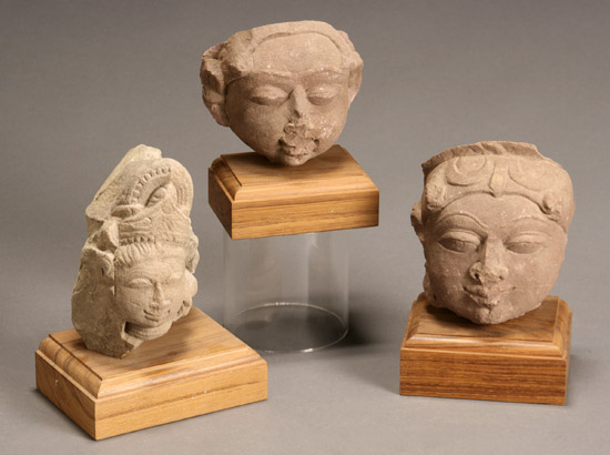 Appraisal: Three Northern or Central Indian Pink-Buff Sandstone Heads of Divinities