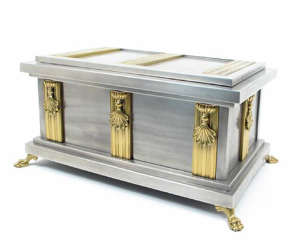 Appraisal: A brushed steel and bronze casket raised on paw feet