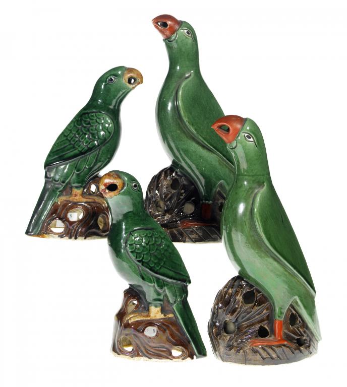 Appraisal: A PAIR OF GREEN GLAZED BISCUIT MODELS OF PARROTS the