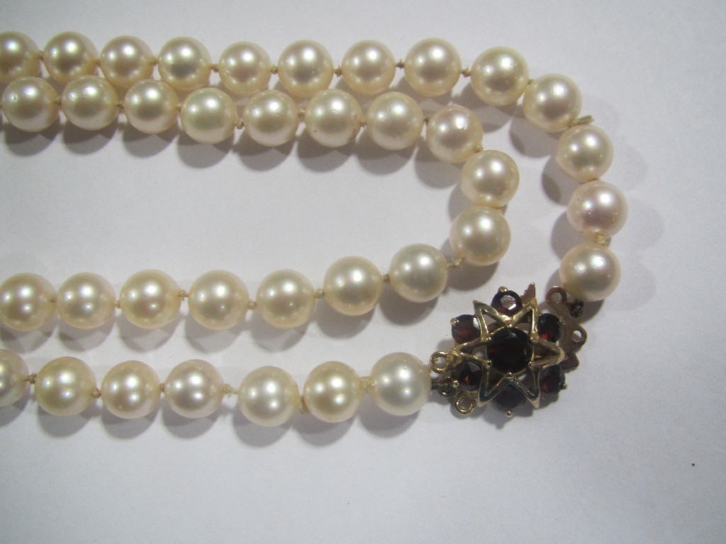 Appraisal: Long string of cultured pearls with ct gold garnet set