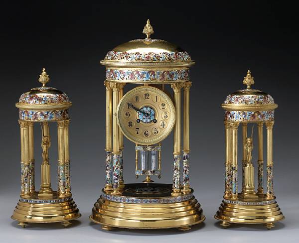 Appraisal: A French gilt bronze and champlev enamel architectural clock garniture