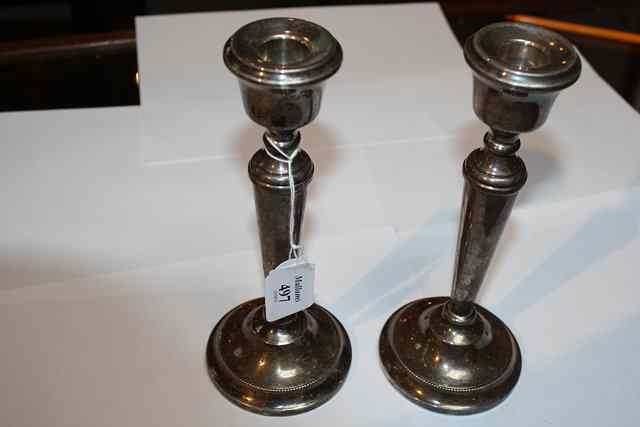 Appraisal: A PAIR OF SILVER CANDLESTICKS on turned stepped feet with