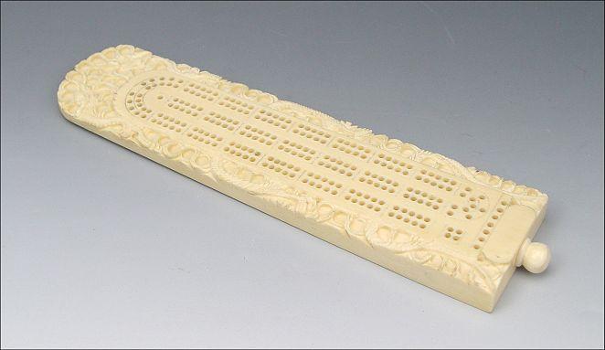 Appraisal: CARVED IVORY CRIBBAGE BOARD Carved with serpent and scroll design