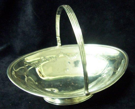 Appraisal: An oval swing handled basket with reeded handle and engraved