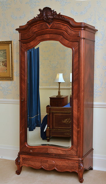 Appraisal: A FRENCH WALNUT ARMOIRE the shaped top with shell and