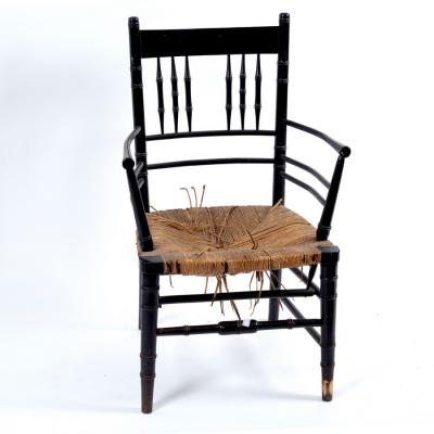 Appraisal: A Morris Co ebonised armchair with rush seat