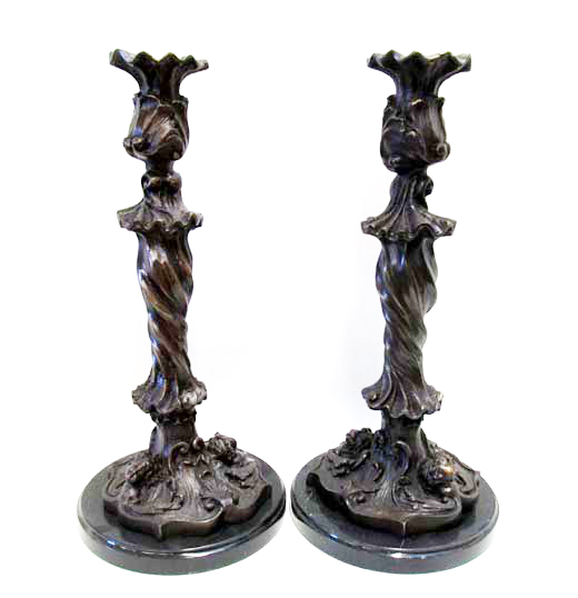 Appraisal: PAIR OF ROCOCO REVIVAL BRONZE CANDLESTICKS having high-relief images of