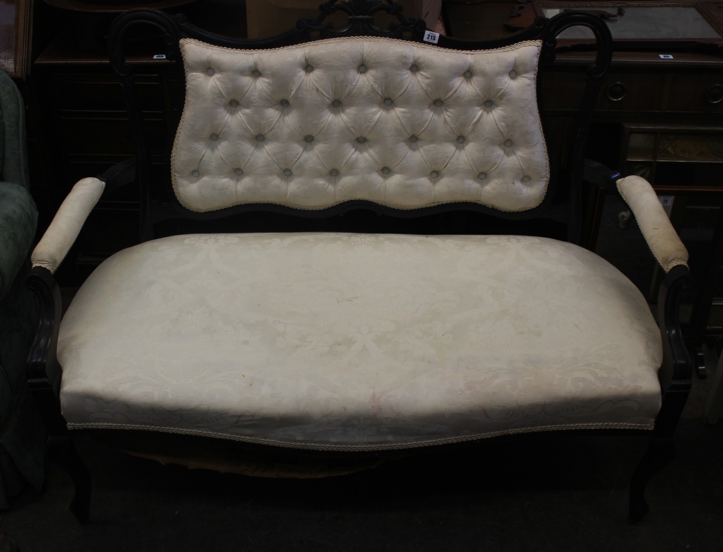 Appraisal: An Edwardian ebonised frame button down upholstered salon settee on