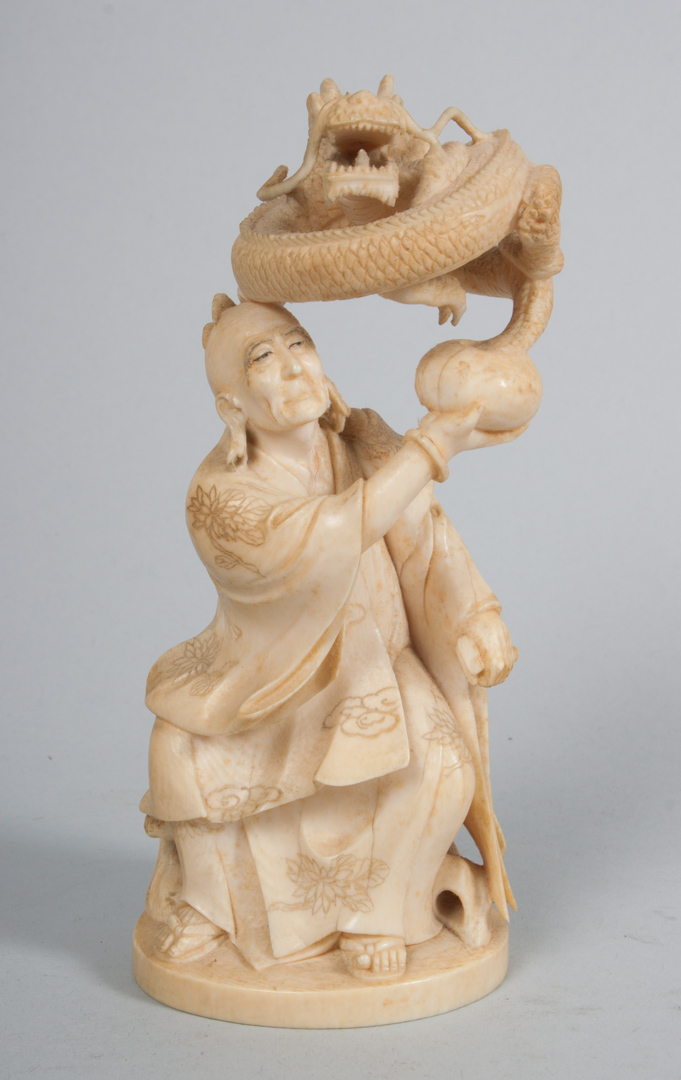 Appraisal: Japanese carved ivory sage with dragon modeled as robed mystic