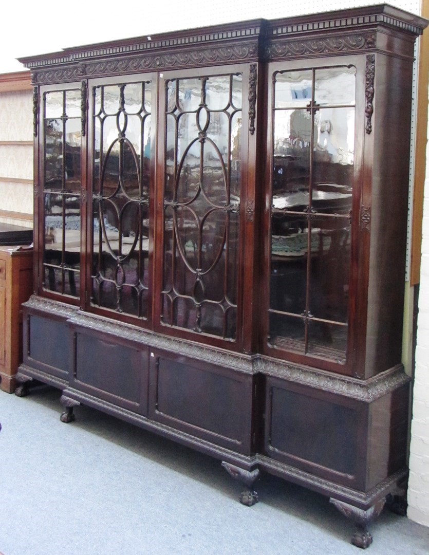 Appraisal: An early th century carved mahogany breakfront bookcase cupboard the