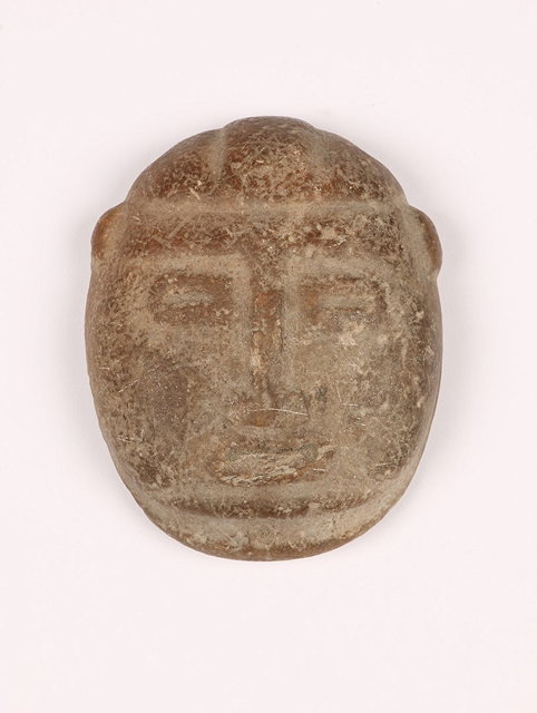 Appraisal: A MEXICAN CARVED STONE FACE PENDANT with two holes for