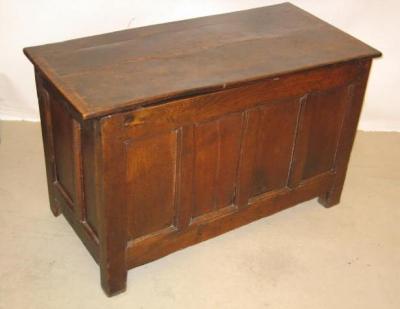 Appraisal: AN OAK PANELLED COFFER with hinged plank lid the fascia