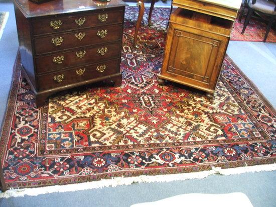 Appraisal: A PERSIAN RED GROUND CARPET decorated a central geometric medallion