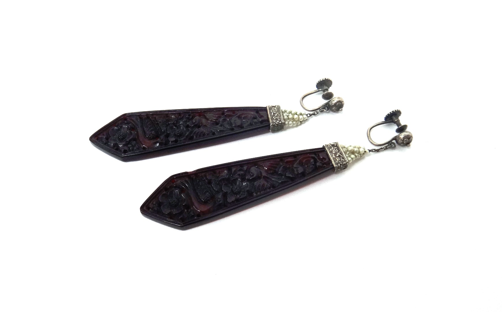 Appraisal: A pair of carved red amber drop shaped earrings probably