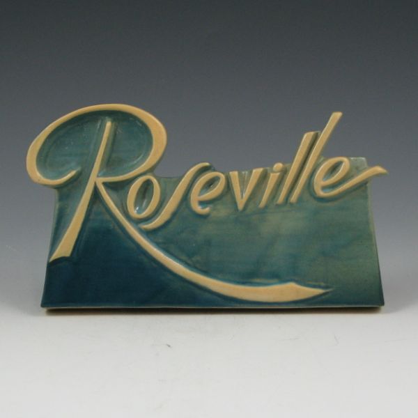 Appraisal: Roseville dealer sign in blue with cream-colored script logo There