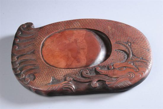 Appraisal: CHINESE RED ORANGE AND RUSSET INKSTONE In form of dragon