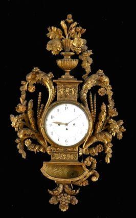 Appraisal: LOUIS XVI-STYLE CARVED GILTWOOD WALL CLOCK The enamel dial within