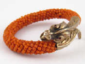 Appraisal: A beaded coral bangle with French hallmarked silver gilt dragon