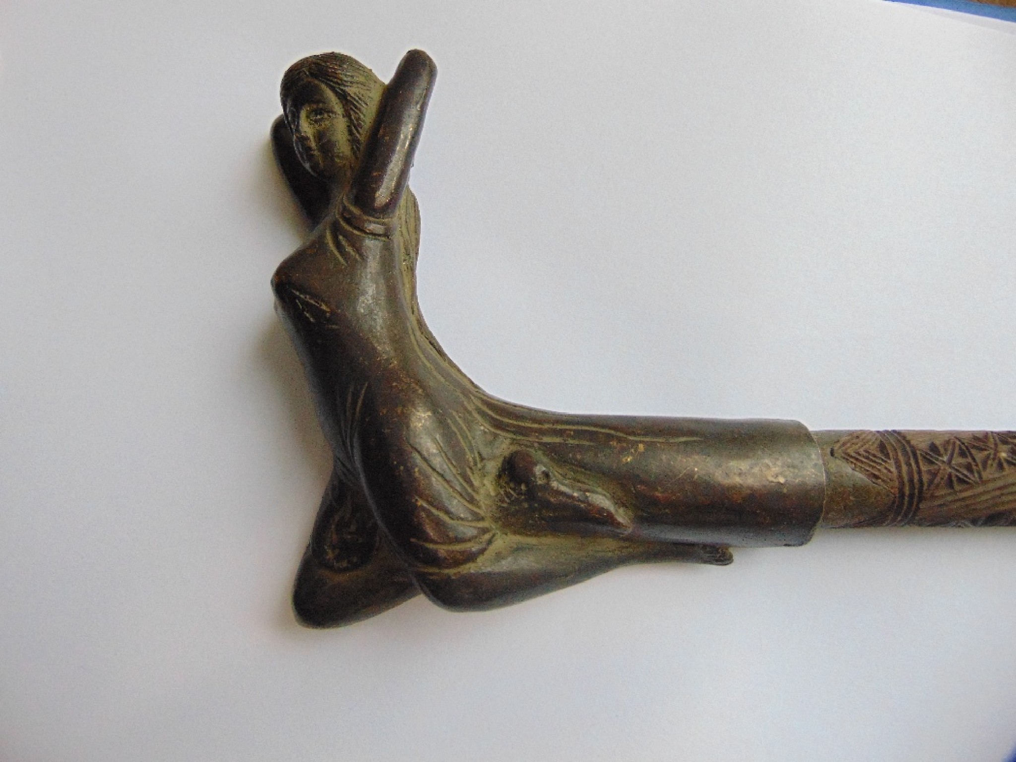 Appraisal: An incised timber walking cane terminating in an applied bronzed