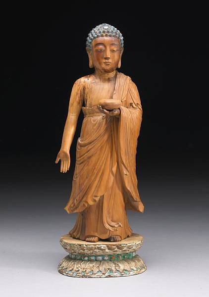 Appraisal: A carved wood standing Buddha The figure holding a begging