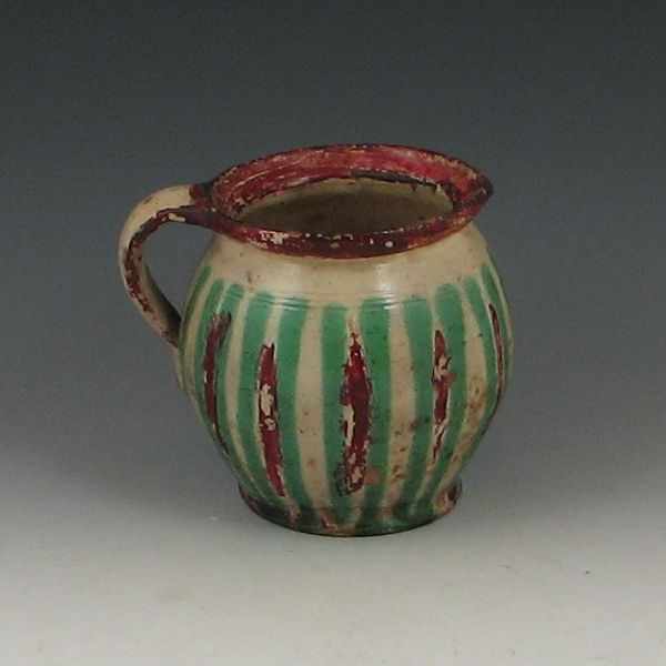 Appraisal: Decorated Pitcher tan green and red ''h pitting in the