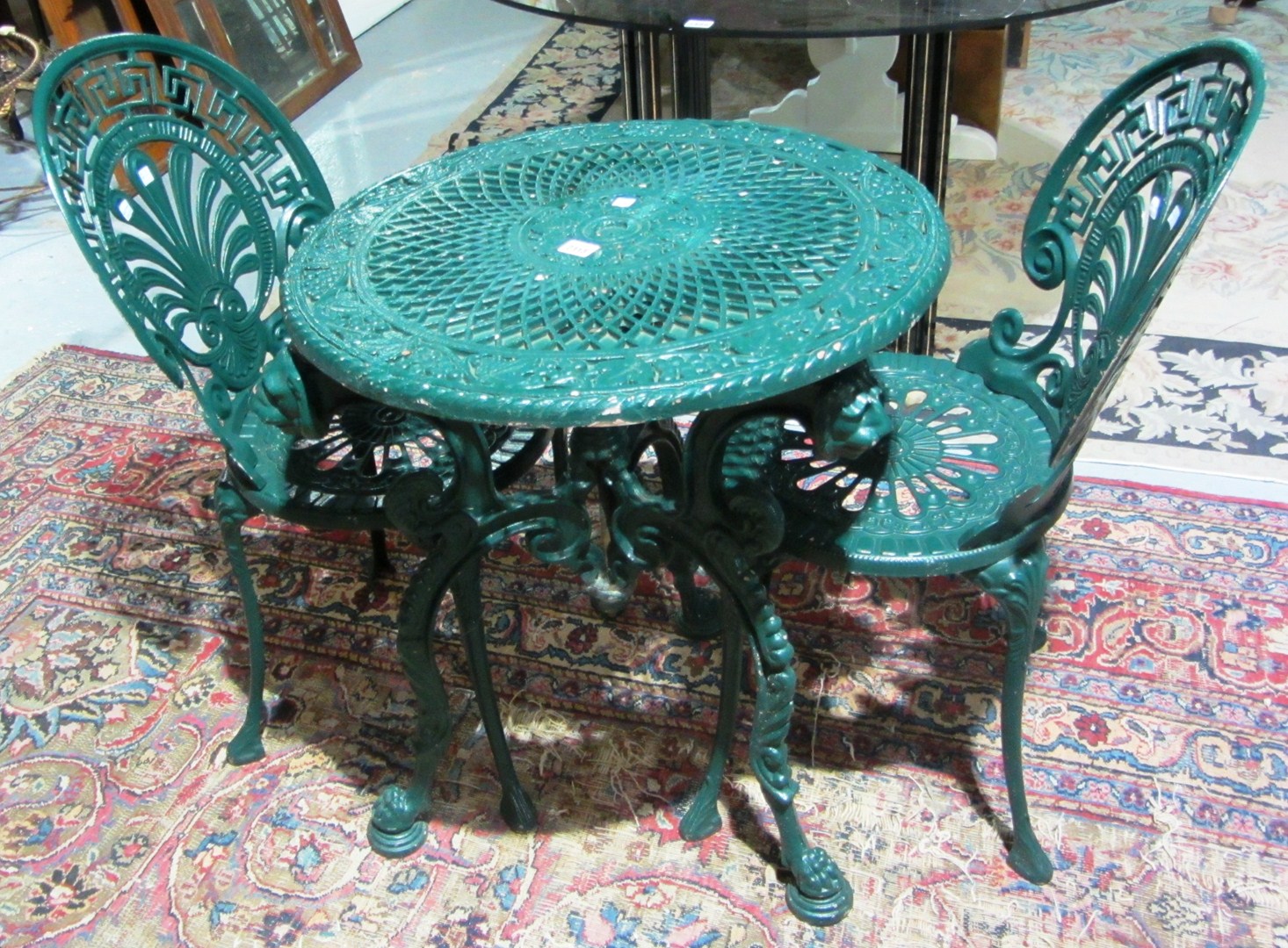 Appraisal: A green painted wrought iron garden table with two matching