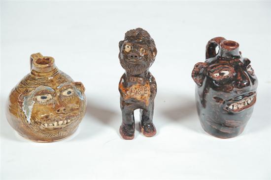 Appraisal: TWO GROTESQUE JUGS AND A FIGURE American th century pottery