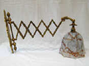 Appraisal: A brass wall mounted lazy tongs extending lamp with bluebell