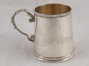 Appraisal: A silver christening cup with beaded rims and scrolling handle