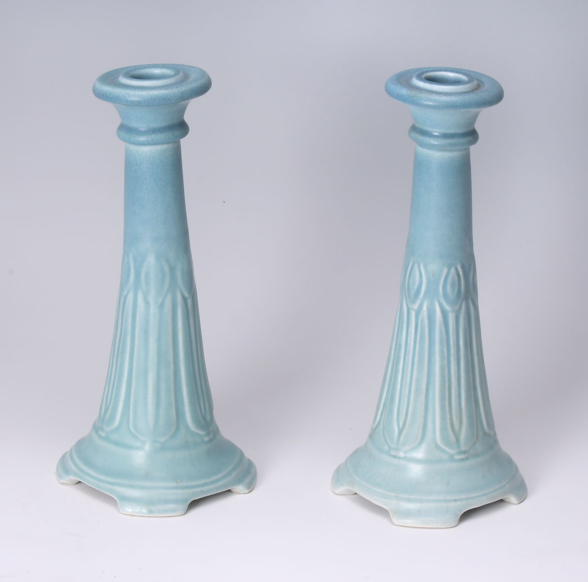 Appraisal: PAIR OF ROOKWOOD CANDLESTICKS form having a raised encompassing Tulip