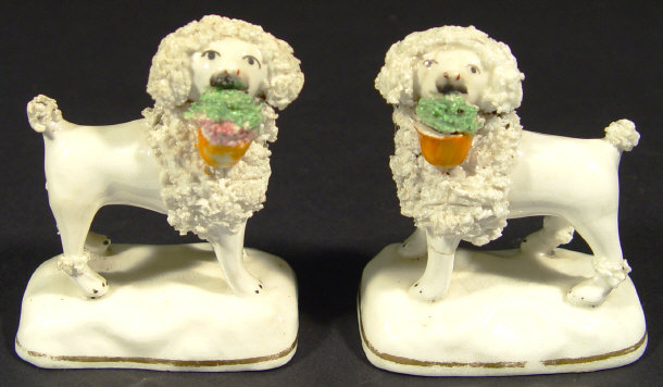 Appraisal: Pair of th Century Staffordshire spaniels holding baskets of flowers