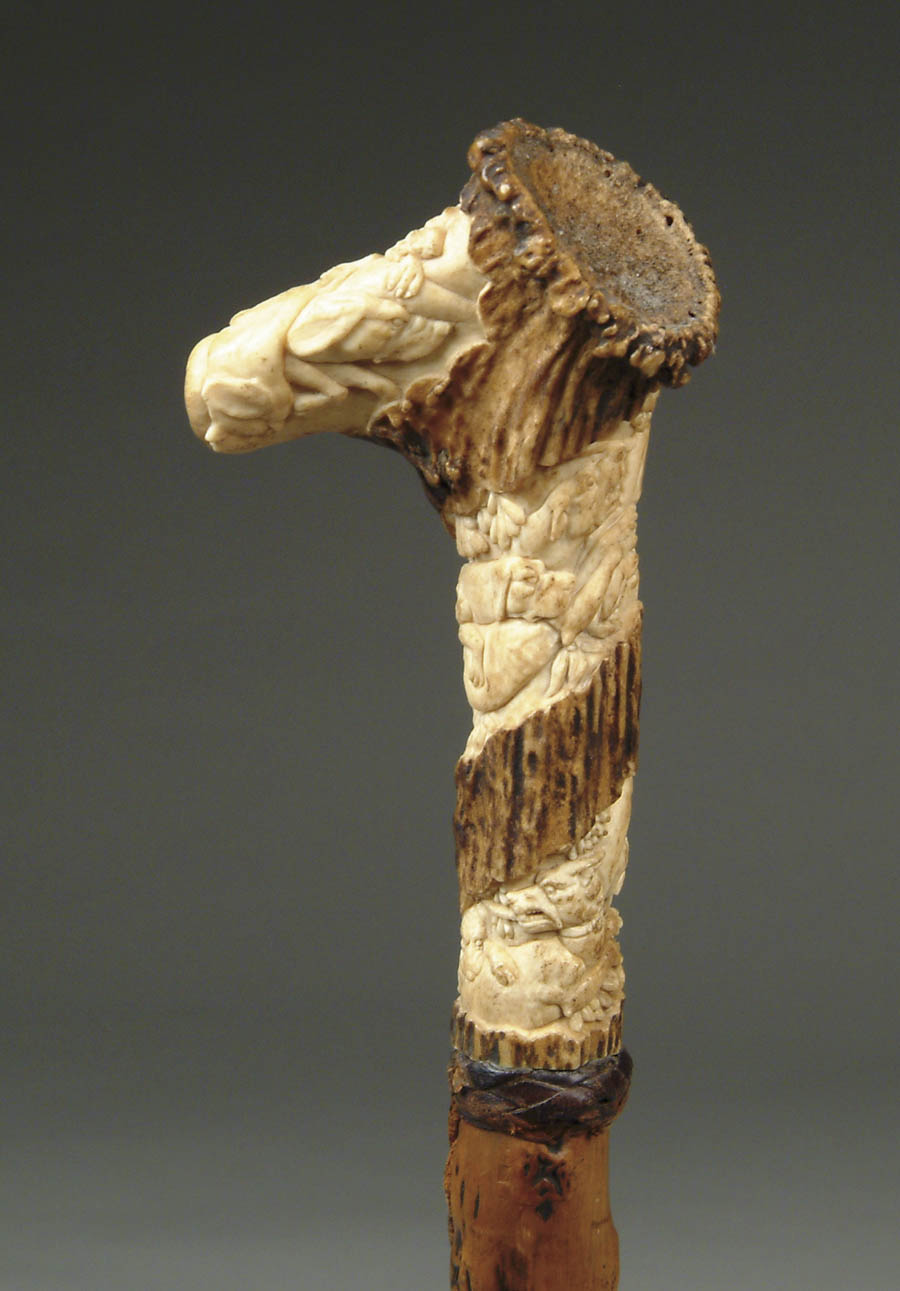 Appraisal: CARVED STAG HORN CANE WITH PACK OF HOUNDS L-shaped with