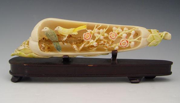 Appraisal: CHINESE CARVED DYED IVORY DIORAMA Elongated fruit with birds cat