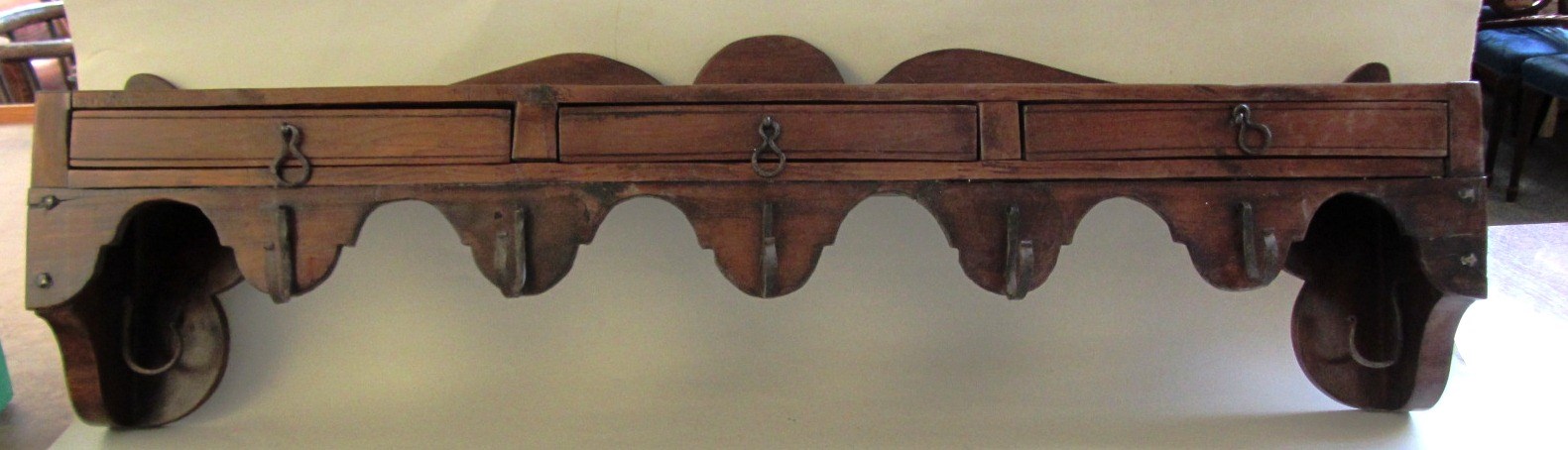 Appraisal: A yew hanging rack with three drawers and wavy frieze