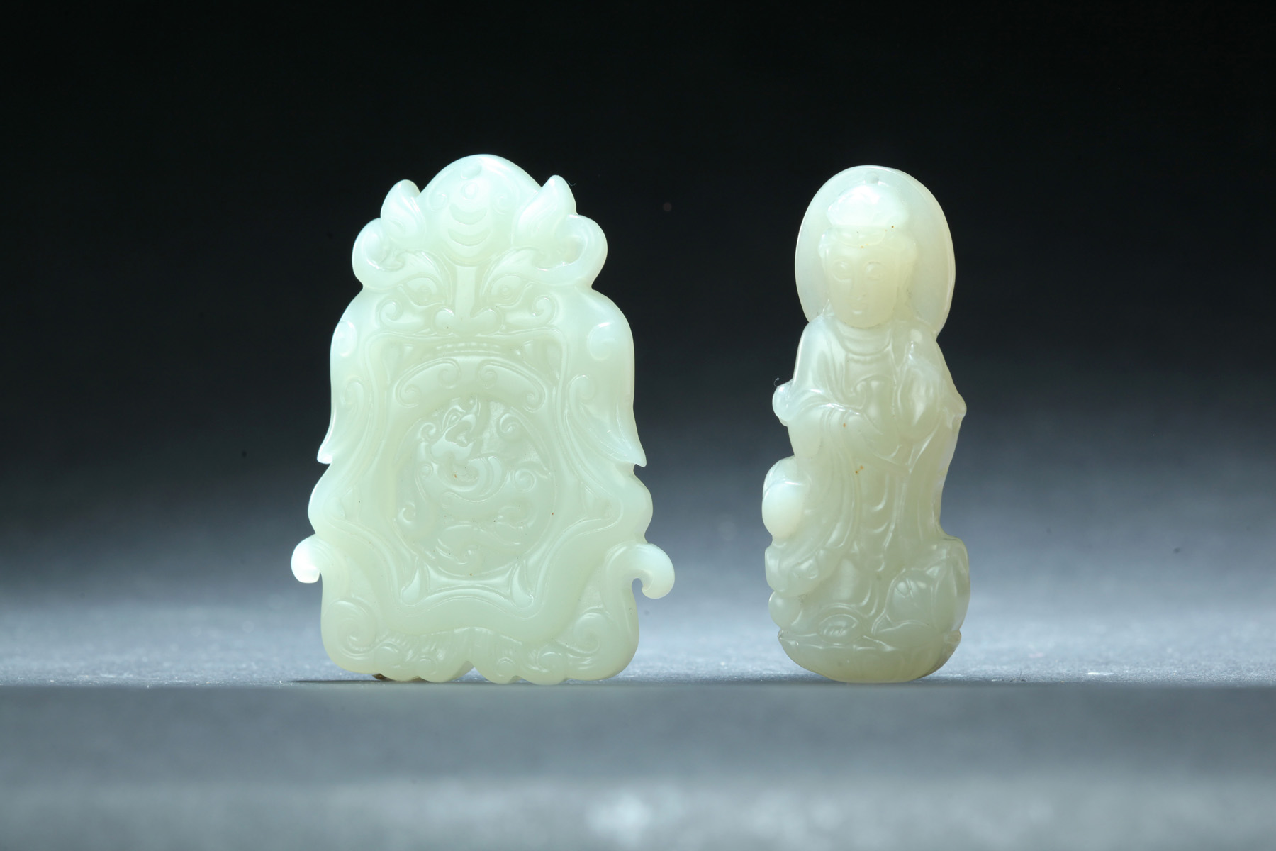 Appraisal: TWO JADE CARVINGS China th century Buddha and a mask