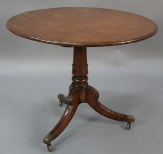 Appraisal: Mahogany tip table on turned shaft set on three downswept