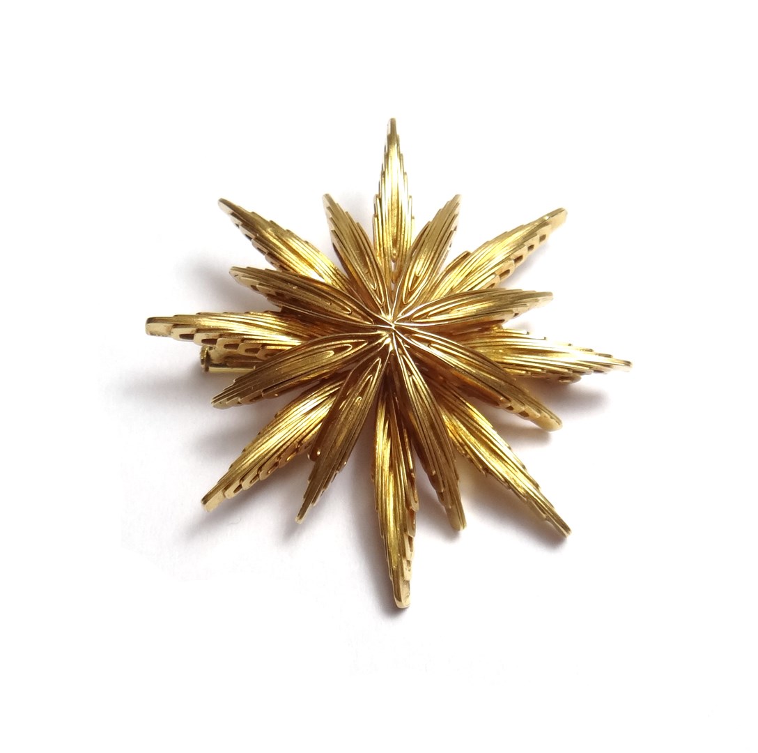 Appraisal: A gold brooch designed as a stylized starburst detailed gross