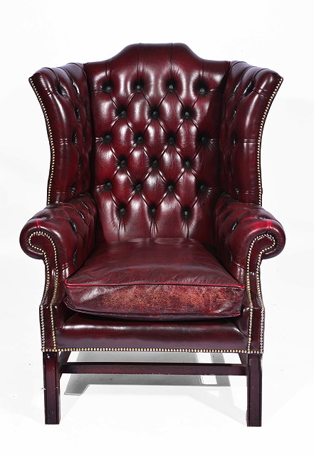 Appraisal: AN OXBLOOD LEATHER WINGBACK ARMCHAIR standing on square section legs