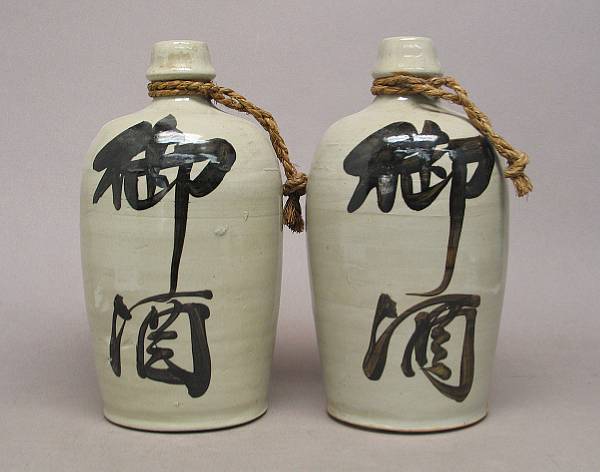 Appraisal: A pair of Japanese glazed stoneware sake bottles Each inscribed