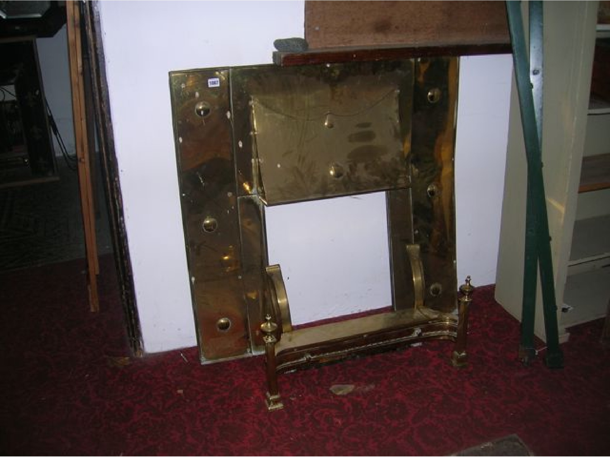 Appraisal: A polished sheet brass fire surround insert with pronounced canopy