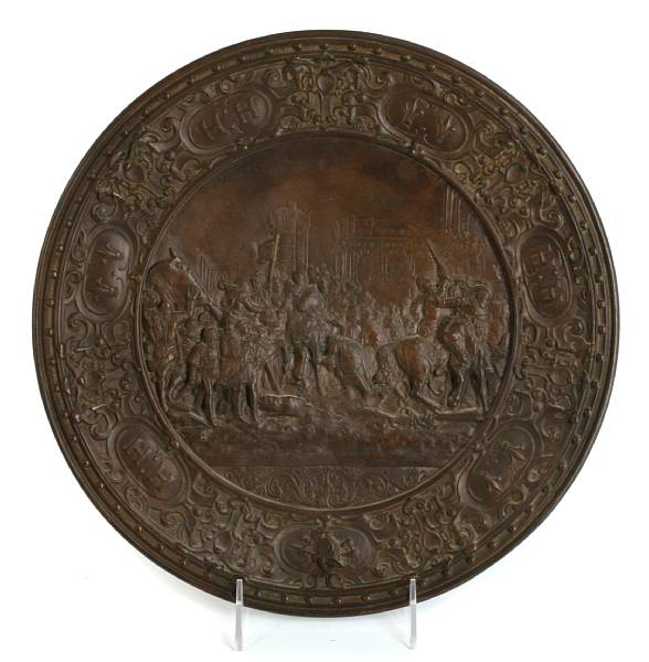 Appraisal: A patinated pressed metal wall plate depicting a battle scene