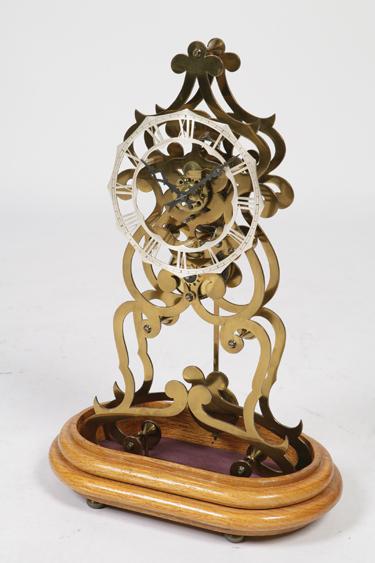 Appraisal: A VICTORIAN STYLE SKELETON CLOCK with twin pierced scrolling brass